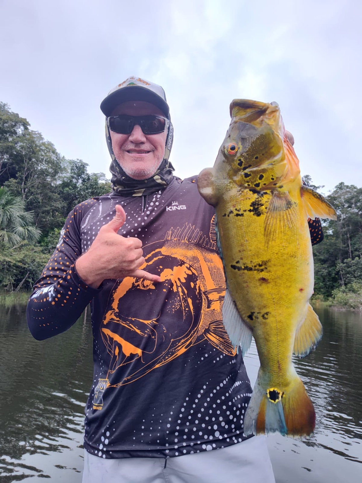 Ercio segurando um tucunaré numa pescaria na Amazônia